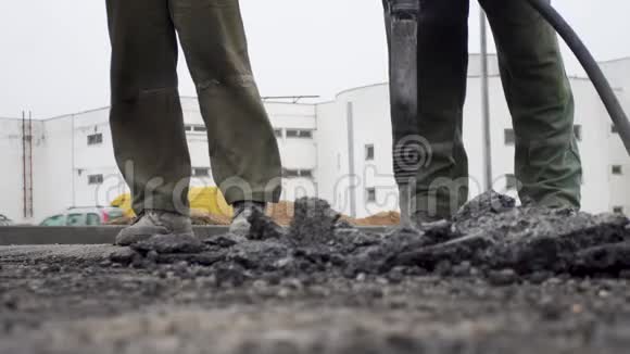 两个成年男子工作摧毁旧沥青打手为人民建设新道路视频的预览图
