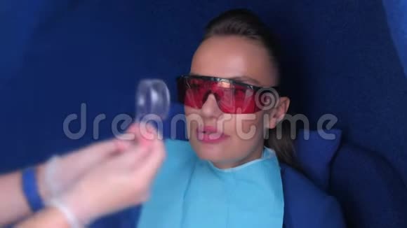 护士准备妇女LED美白牙齿安装牙科拉钩视频的预览图