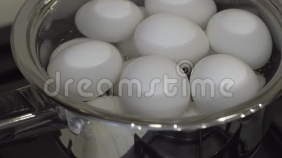 生的白鸡蛋在金属平底锅中煮熟健康的早餐烹饪视频的预览图