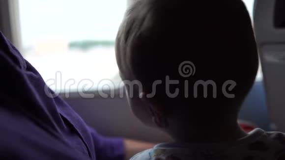 母亲带着孩子坐在飞机窗口附近等待起飞视频的预览图