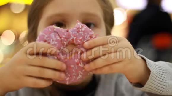 孩子吃甜甜圈特写女婴吃带釉面的甜甜圈美味甜蜜甜蜜的牙齿视频的预览图