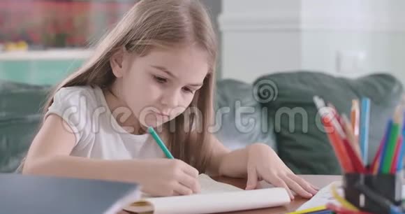 在家做数学的白人女孩的特写聪明的女学生在桌子上做作业教育视频的预览图