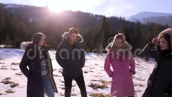 在一个阳光明媚的冬天三个女孩和一个男孩在蓝天上玩得很开心健康生活方式的概念视频的预览图