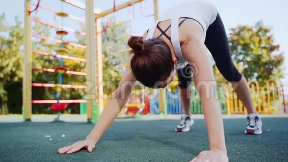 运动的女人在新鲜空气中锻炼后做伸展运动那个女孩在街上参加体育活动视频的预览图