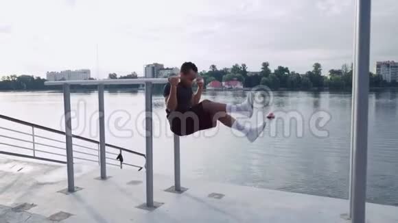在湖边做腹部运动的肌肉男视频的预览图