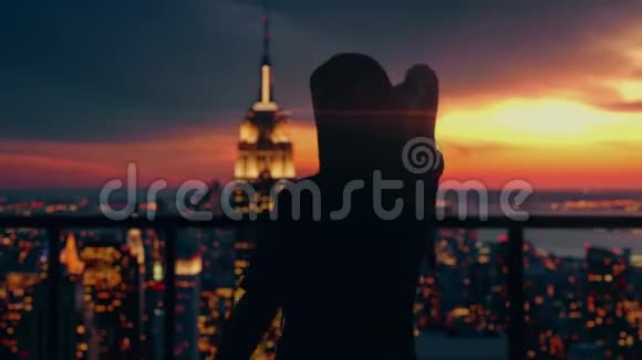 女游客在屋顶上跳舞可以看到纽约市的景色背景是灯光自由和旅行视频的预览图