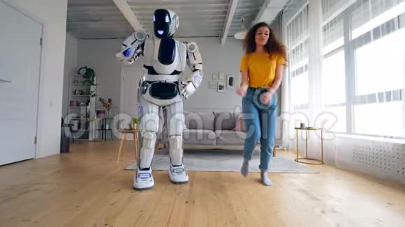 白人机器人和女孩一起跳舞机器人和人类的合作视频的预览图