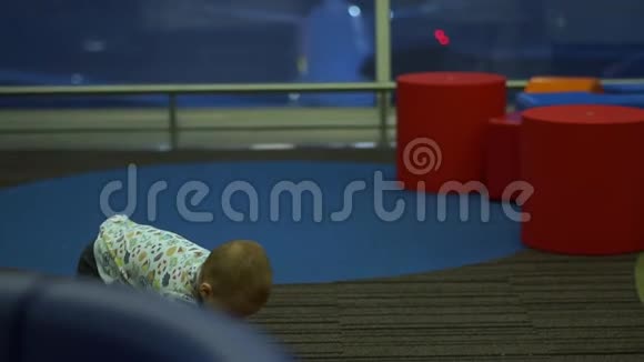 一个蹒跚学步的孩子在机场的儿童游戏区欢快地跑着缓慢视频的预览图