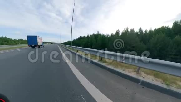 驾驶摩托车的司机沿高路侧视摩托车在路上视频的预览图