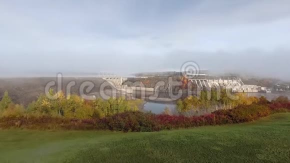 在晴朗的秋日无人机照相机在平静的河流上接近一座封闭的大坝视频的预览图