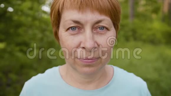花园中绿色背景的高级妇女肖像视频的预览图