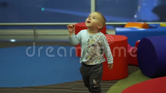 小男孩兴高采烈地跑在机场的儿童游乐区慢动作视频的预览图