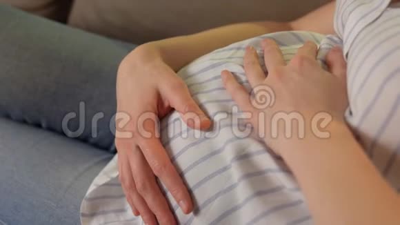 快乐的孕妇在家抱着肚子视频的预览图