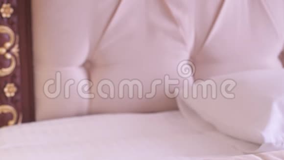 一个女佣在豪华的酒店房间里调整床上的枕头视频的预览图
