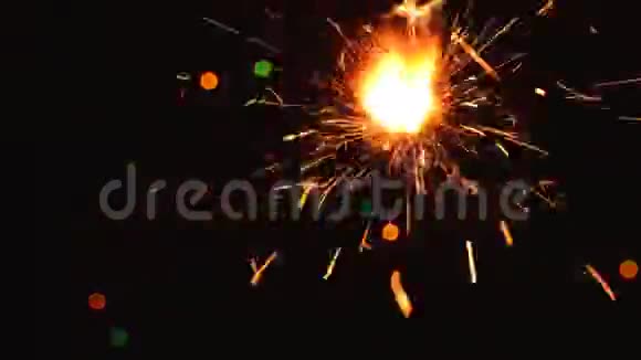 在黑暗的背景上用五颜六色的圣诞灯燃烧着火花视频的预览图