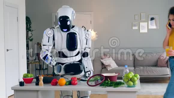 一个女孩在电话里说话而一个机器人在做饭未来主义概念视频的预览图