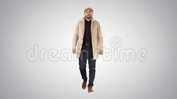 深色胡须的人穿着浅色的风衣在渐变背景下行走视频的预览图