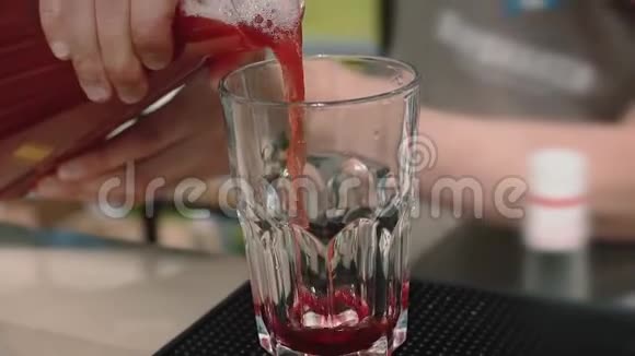当他们用冰块倒入含酒精的红色鸡尾酒时动作缓慢视频的预览图