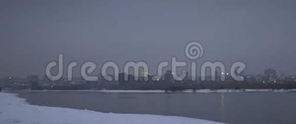 运动员在黄昏时分在河岸的雪中完成冬季跑步户外慢跑视频的预览图