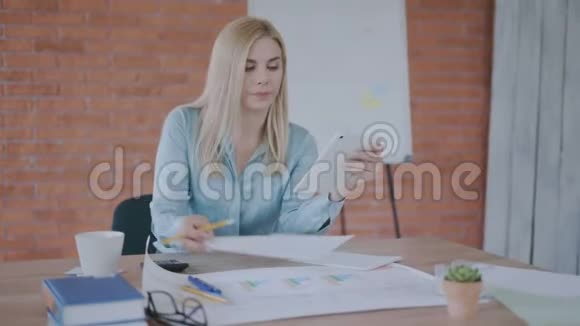 有兴趣的女人看着平板电脑在现代阁楼办公室工作4K视频的预览图