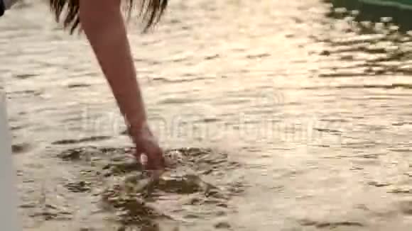 女孩的手在喷泉的水中她在水中玩耍并使飞溅视频的预览图