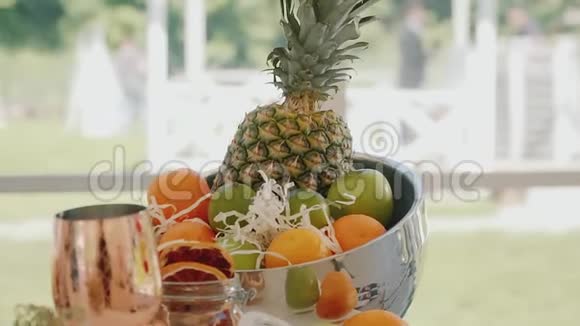 橘子石灰苹果菠萝水果在一个圆形的金属碗里水果碗视频的预览图