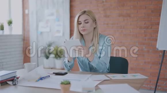 迷人的集中妇女35岁工作与文件和平板电脑在现代阁楼办公室工作4K视频的预览图