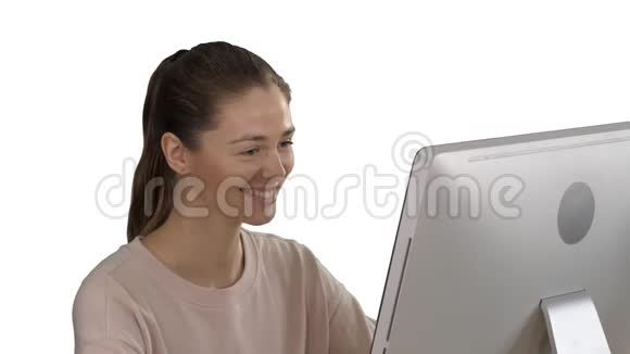 学生金发女孩看着电脑显示器在白色背景上微笑视频的预览图