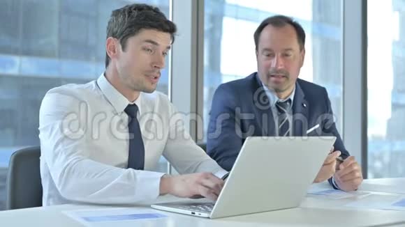 开朗的商人在笔记本电脑上讨论项目视频的预览图