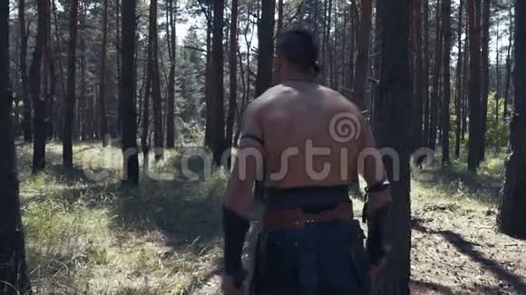 双手拿着斧头的野蛮勇士正在砍树枝视频的预览图