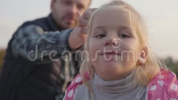 一个金发棕色眼睛的小可爱女孩的特写镜头可爱的孩子坐着视频的预览图