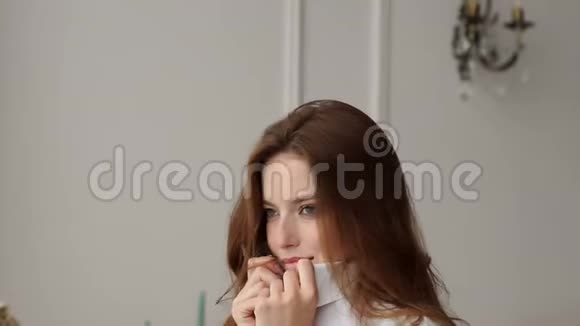 早晨一个长着红色长发的性感少女站在窗边视频的预览图