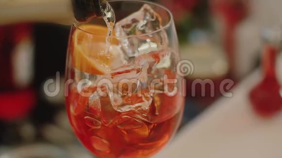 香槟酒慢慢地倒入一个杯子里杯中放着淡淡的冰视频的预览图