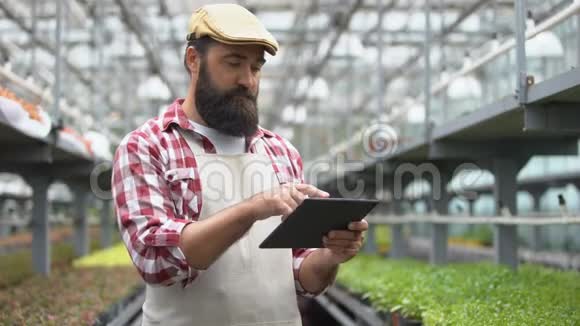 农民在平板电脑上使用农业应用程序智能温室灌溉系统视频的预览图