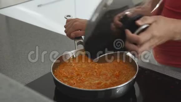 厨房里的女人在炉子上准备着一个煎锅里面有扁豆和胡萝卜健康的饮食有很多视频的预览图