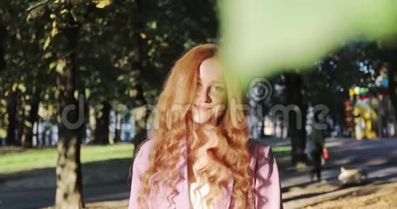 年轻女性模特的肖像自然雀斑在明亮的阳光下调整头发视频的预览图