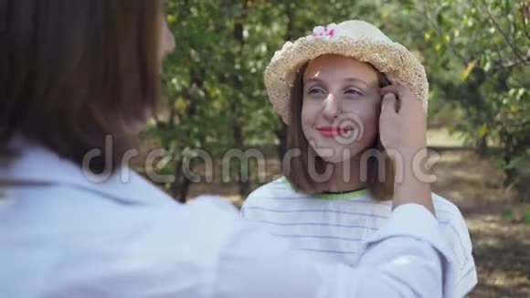 可爱的夫妇站在公园里一个留着长发的男人摸着戴帽子的漂亮女人的头发情人花时间视频的预览图
