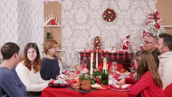 大家庭聚集在圣诞餐桌上享用着传统食物视频的预览图