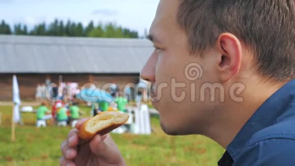 一个年轻人在节日或乡村集市上吃馅饼视频的预览图