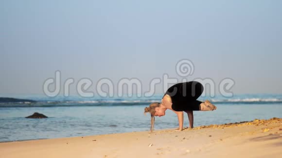 金发女人在沙滩海岸做瑜伽姿势乌鸦视频的预览图