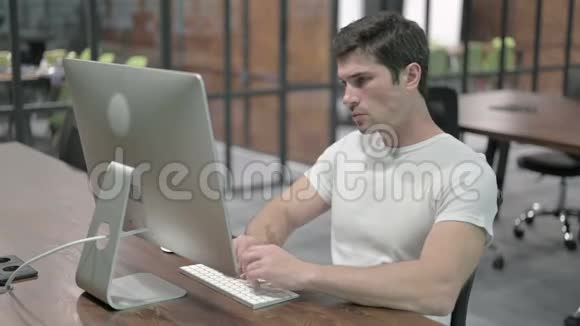 背痛不舒服的年轻人在电脑上工作视频的预览图