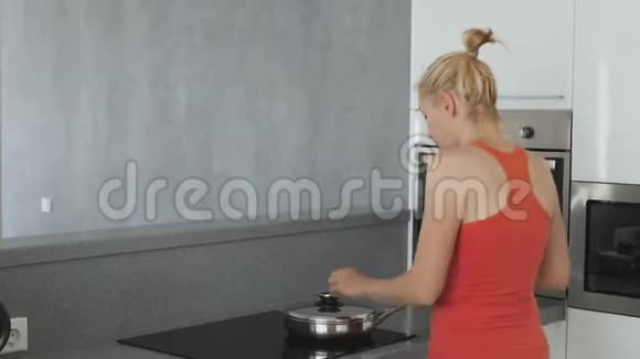 厨房里的女人在炉子上准备着一个煎锅里面有扁豆和胡萝卜健康的饮食有很多视频的预览图