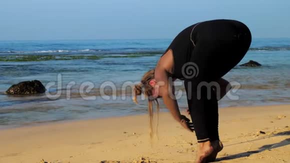 穿黑色运动服的赤脚女孩站在瑜伽姿势上视频的预览图