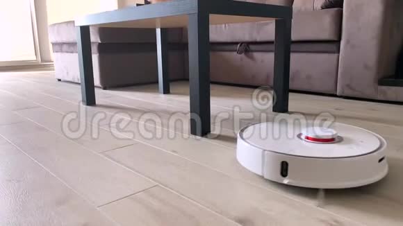 智慧之家当女人沙发上玩手机时用机器人吸尘器清洁房子视频的预览图