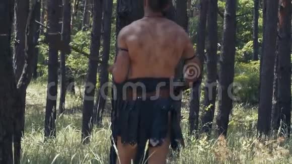 野蛮战士赤裸的躯干在树林里用斧头挥舞视频的预览图