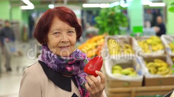 高级妇女在超市的杂货店购物时拿着红辣椒视频的预览图
