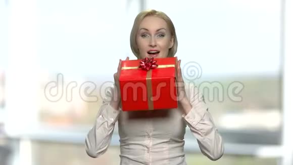 快乐的女人带着红色的礼盒视频的预览图