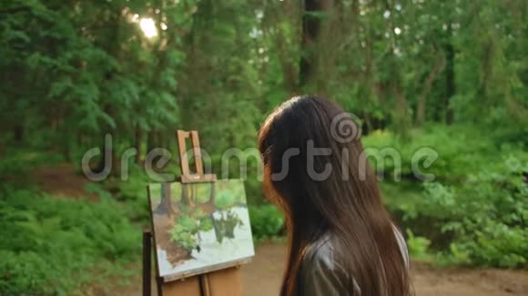 小女孩在公园里画一幅风景油画视频的预览图