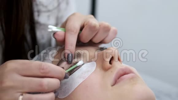 一个睫毛师正在用棉芽在眼睫毛上涂上睫毛视频的预览图