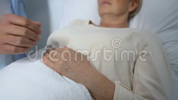有爱心的儿子在医院病房支持和安慰临终的母亲视频的预览图